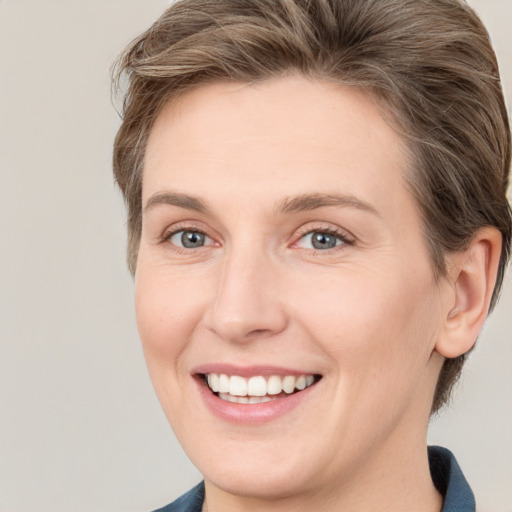 Joyful white young-adult female with medium  brown hair and grey eyes