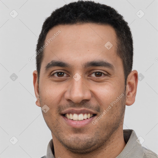 Joyful latino young-adult male with short  black hair and brown eyes