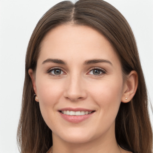 Joyful white young-adult female with long  brown hair and grey eyes