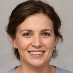 Joyful white adult female with medium  brown hair and grey eyes