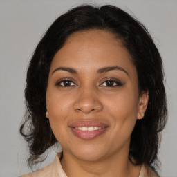 Joyful latino young-adult female with medium  brown hair and brown eyes