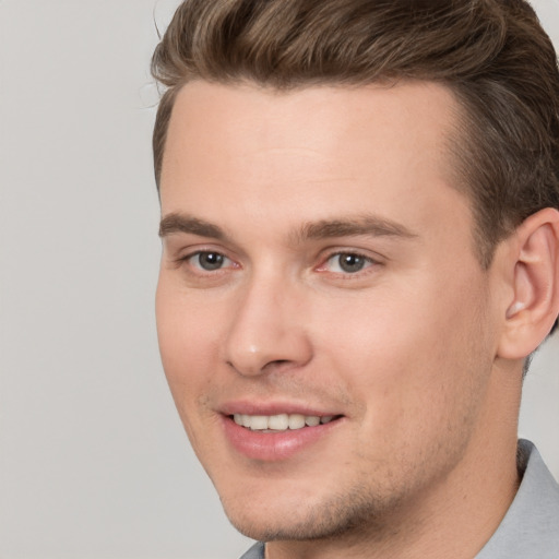 Joyful white young-adult male with short  brown hair and brown eyes