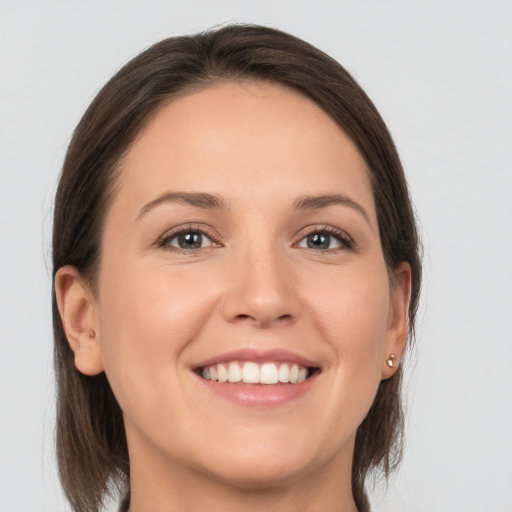 Joyful white young-adult female with long  brown hair and grey eyes