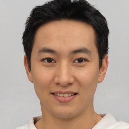 Joyful asian young-adult male with short  black hair and brown eyes