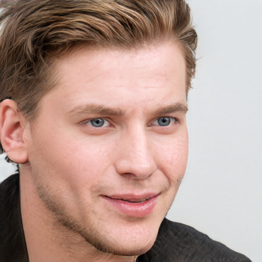 Joyful white young-adult male with short  brown hair and blue eyes