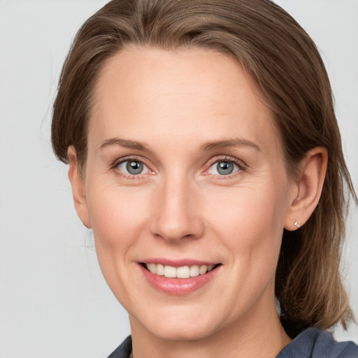 Joyful white young-adult female with medium  brown hair and grey eyes