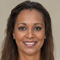 Joyful black adult female with long  brown hair and brown eyes