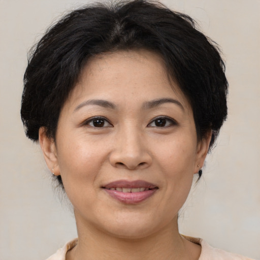 Joyful asian adult female with medium  brown hair and brown eyes