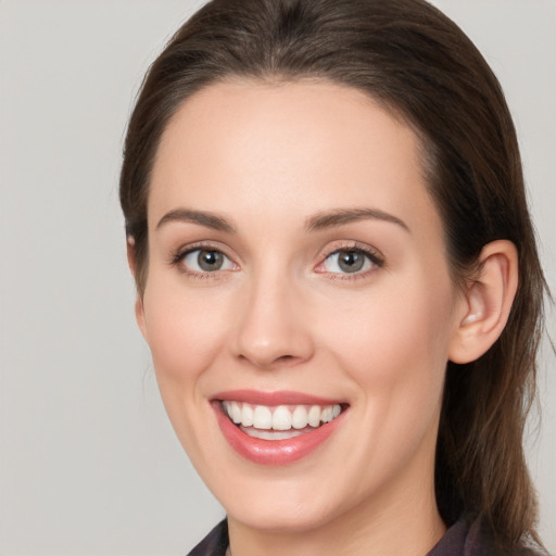 Joyful white young-adult female with medium  brown hair and grey eyes