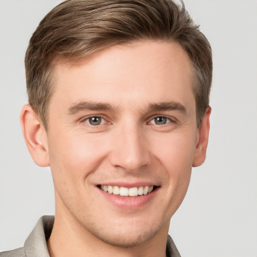 Joyful white young-adult male with short  brown hair and grey eyes