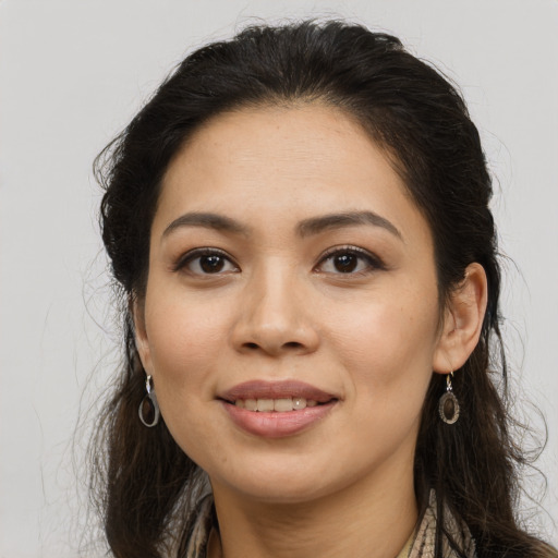 Joyful latino young-adult female with long  brown hair and brown eyes