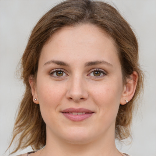 Joyful white young-adult female with medium  brown hair and green eyes