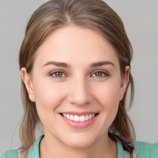 Joyful white young-adult female with medium  brown hair and grey eyes