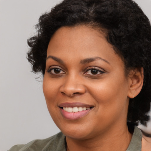 Joyful black young-adult female with medium  black hair and brown eyes