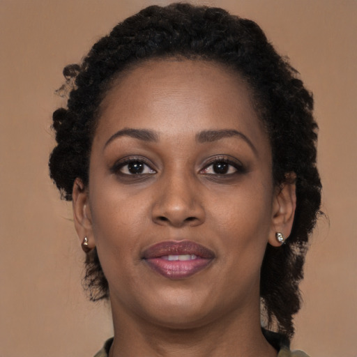 Joyful black young-adult female with long  brown hair and brown eyes