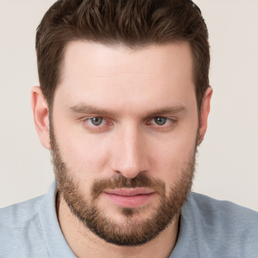 Joyful white young-adult male with short  brown hair and grey eyes