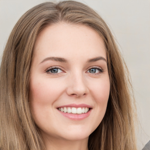 Joyful white young-adult female with long  brown hair and green eyes