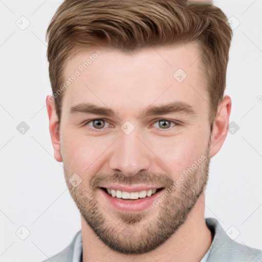 Joyful white young-adult male with short  brown hair and grey eyes