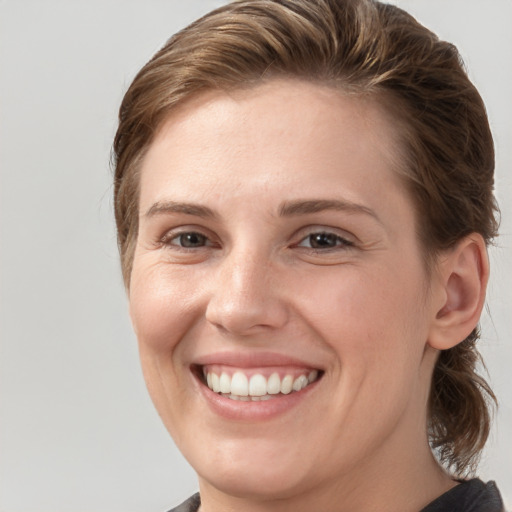 Joyful white young-adult female with medium  brown hair and grey eyes