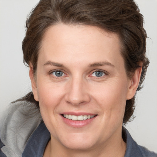 Joyful white adult female with medium  brown hair and grey eyes