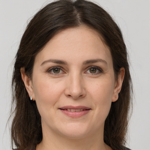 Joyful white adult female with long  brown hair and grey eyes