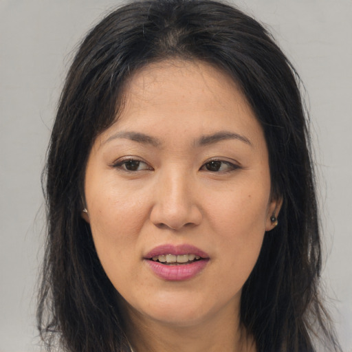 Joyful asian young-adult female with long  brown hair and brown eyes