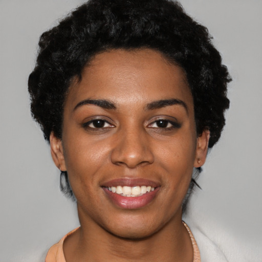 Joyful black young-adult female with short  black hair and brown eyes