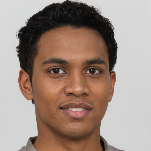Joyful black young-adult male with short  black hair and brown eyes