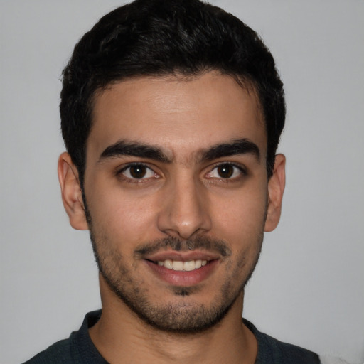 Joyful latino young-adult male with short  brown hair and brown eyes