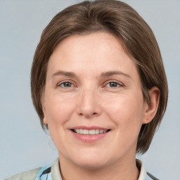 Joyful white adult female with medium  brown hair and grey eyes