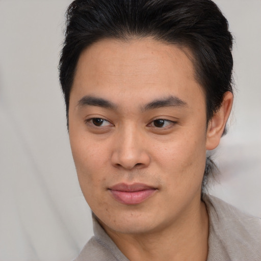 Joyful asian young-adult male with short  brown hair and brown eyes