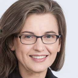 Joyful white adult female with long  brown hair and grey eyes