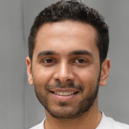 Joyful white young-adult male with short  black hair and brown eyes