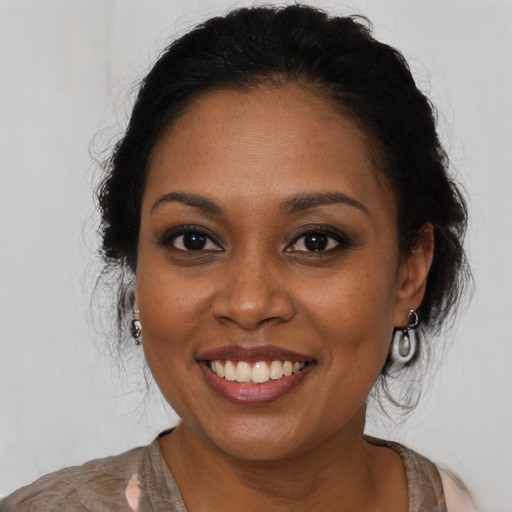 Joyful black young-adult female with long  brown hair and brown eyes