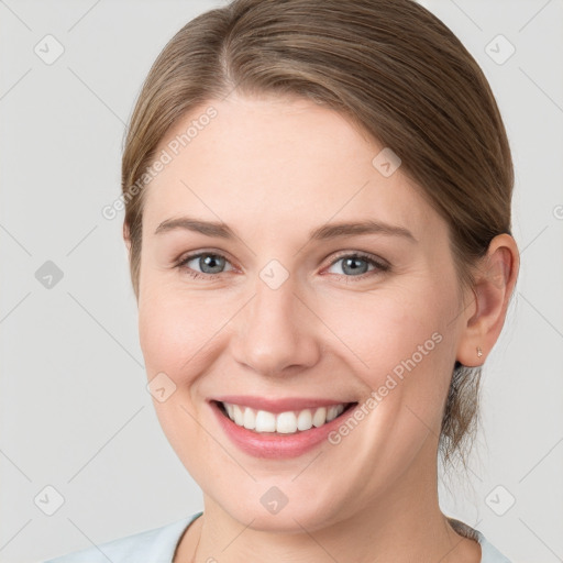 Joyful white young-adult female with medium  brown hair and grey eyes