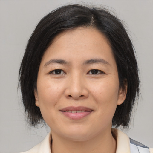 Joyful asian adult female with medium  brown hair and brown eyes