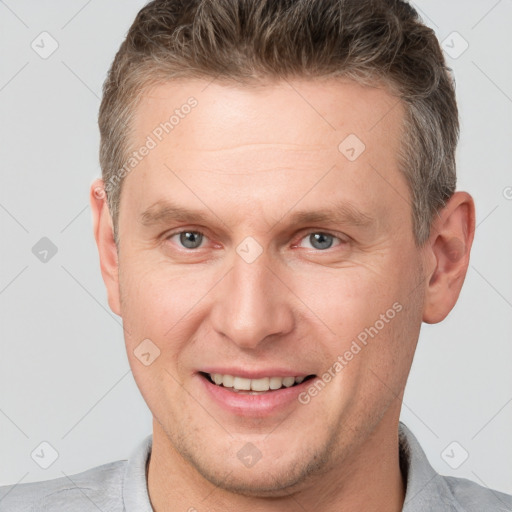 Joyful white adult male with short  brown hair and grey eyes