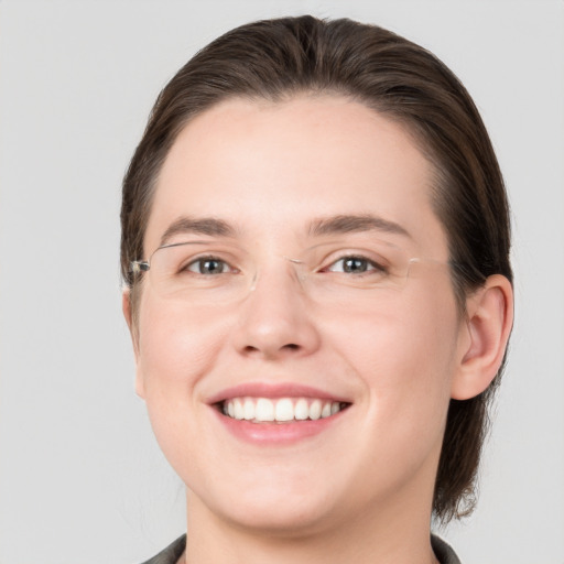 Joyful white young-adult female with medium  brown hair and grey eyes