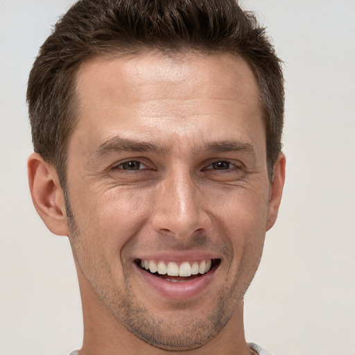 Joyful white adult male with short  brown hair and brown eyes