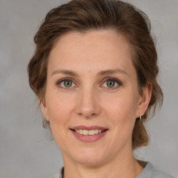 Joyful white adult female with medium  brown hair and grey eyes