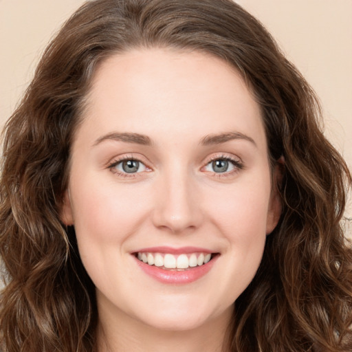 Joyful white young-adult female with long  brown hair and green eyes