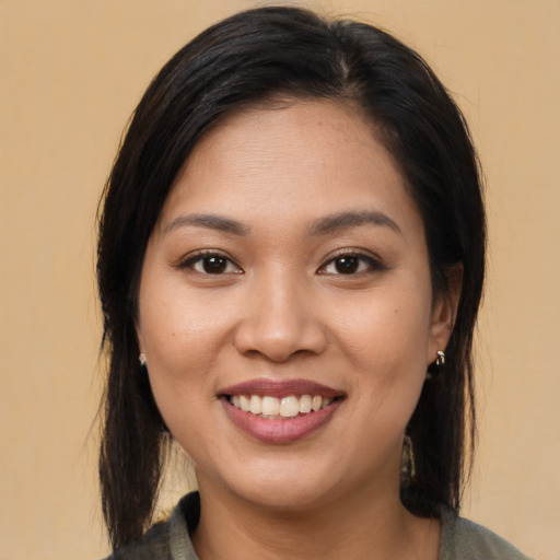 Joyful latino young-adult female with long  brown hair and brown eyes