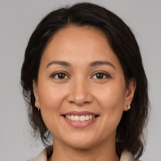 Joyful white adult female with medium  brown hair and brown eyes