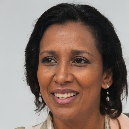 Joyful black adult female with long  brown hair and brown eyes