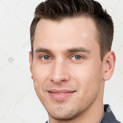 Joyful white young-adult male with short  brown hair and brown eyes