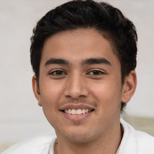 Joyful latino young-adult male with short  brown hair and brown eyes