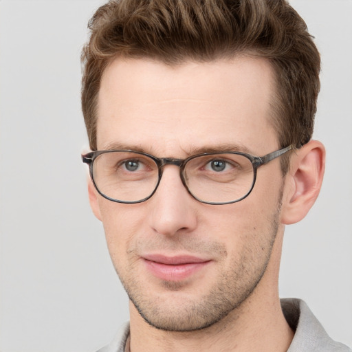 Joyful white young-adult male with short  brown hair and grey eyes