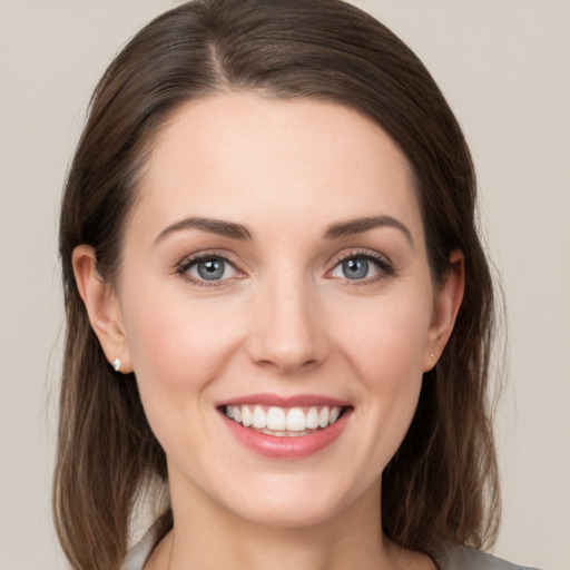 Joyful white young-adult female with medium  brown hair and grey eyes