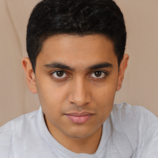 Joyful latino young-adult male with short  brown hair and brown eyes