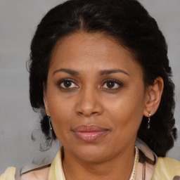 Joyful black adult female with medium  brown hair and brown eyes